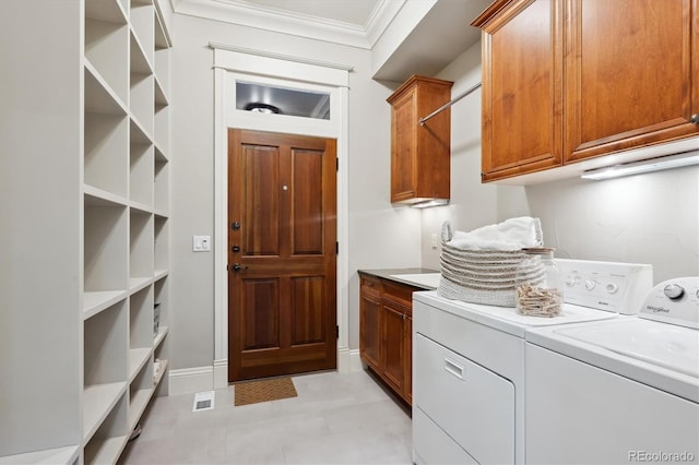 washroom with cabinet space, crown molding, baseboards, and separate washer and dryer