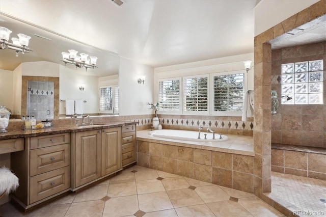 full bathroom featuring a garden tub, vanity, a tile shower, tile patterned floors, and an inviting chandelier