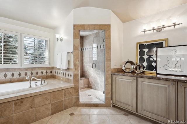 bathroom featuring a garden tub, a shower stall, and tile patterned floors