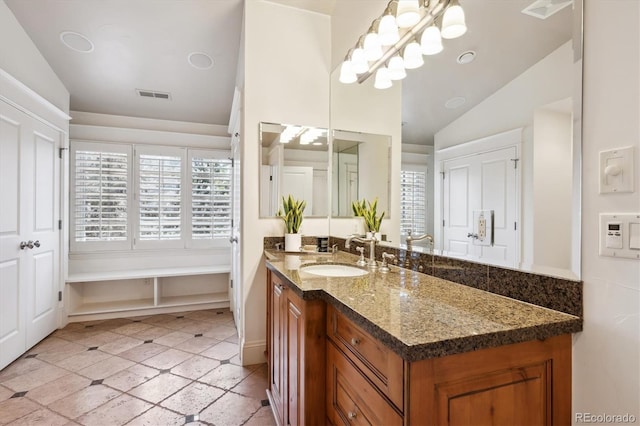 bathroom featuring lofted ceiling, visible vents, and vanity