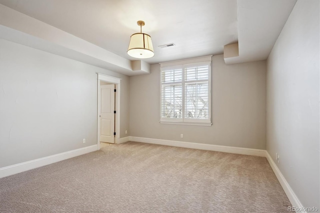 spare room with light carpet, visible vents, and baseboards