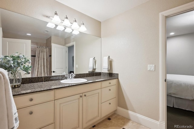 bathroom with ensuite bathroom, curtained shower, vanity, baseboards, and tile patterned floors