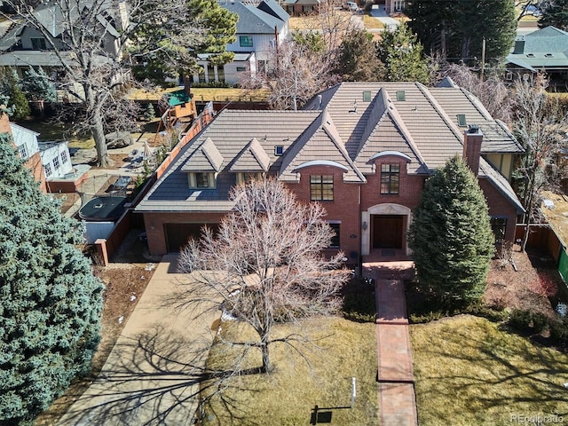 view of front facade with a front yard, brick siding, and a tiled roof