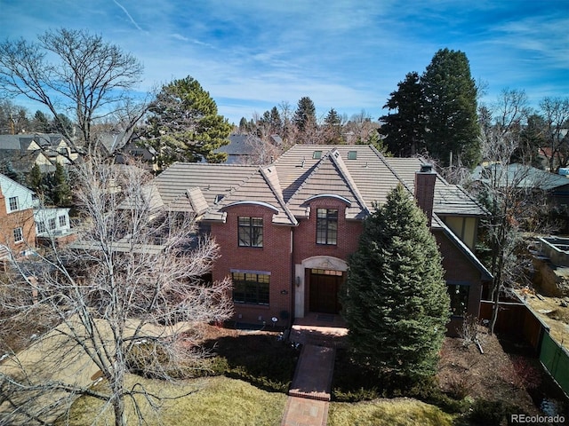 view of front facade with brick siding and a tile roof