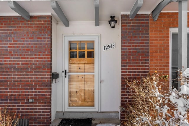 view of exterior entry with brick siding