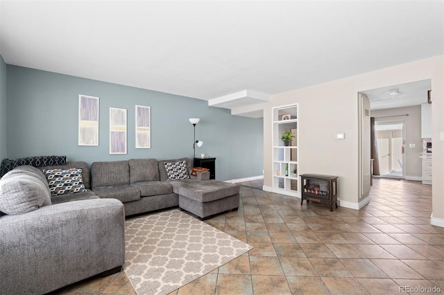 living area with a wood stove, baseboards, and built in features