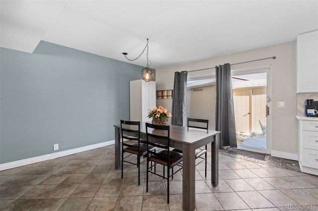 dining space featuring light tile patterned flooring and baseboards