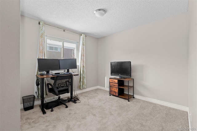 home office featuring a textured ceiling, carpet floors, and baseboards