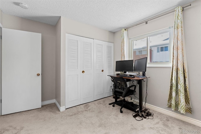 office area featuring carpet, a textured ceiling, and baseboards