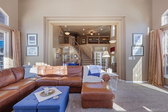 carpeted living room with a towering ceiling