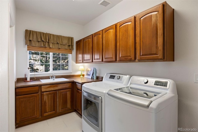 clothes washing area featuring cabinets, washer and clothes dryer, and sink