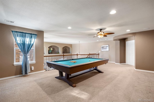 recreation room featuring ceiling fan, light colored carpet, and a textured ceiling