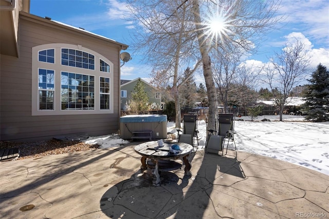 snow covered patio with a hot tub