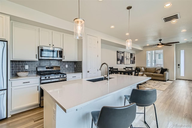 12345 Festival Ln, Thornton, CO 80241 - kitchen featuring appliances with stainless steel finishes, decorative backsplash, light wood finished floors, light countertops, and recessed lighting