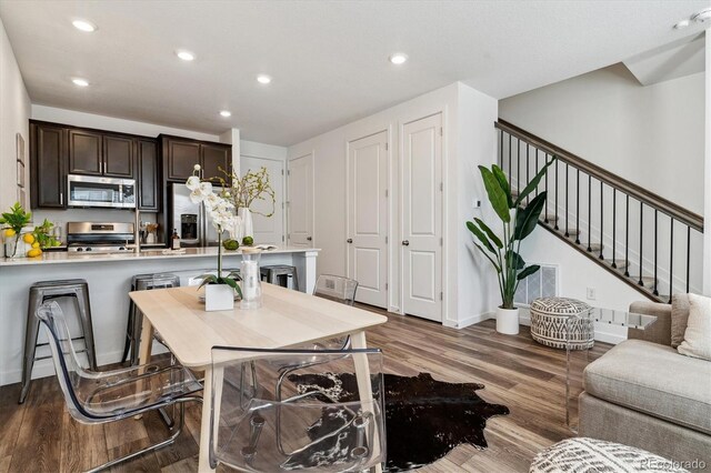 dining area with recessed lighting, stairway, wood finished floors, visible vents, and baseboards
