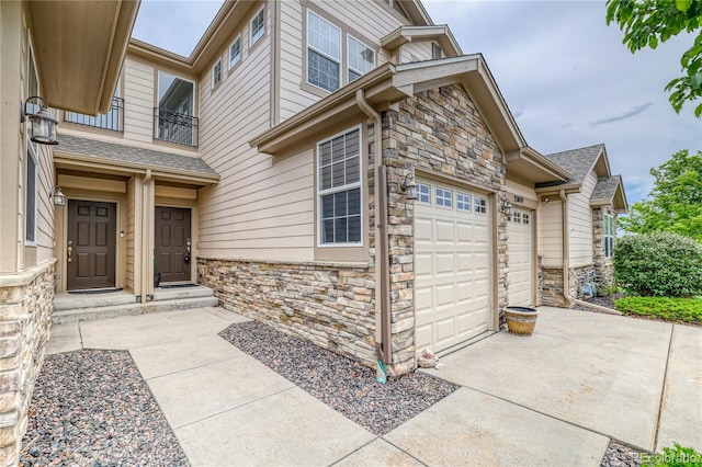 23070 York Ave, Parker, CO 80138 - doorway to property with stone siding, a balcony, a garage, and concrete driveway