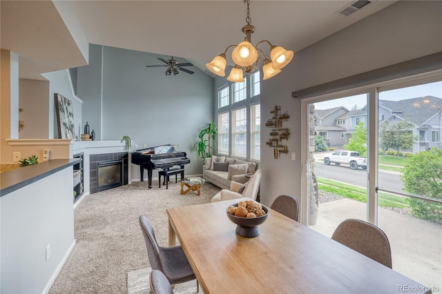 23070 York Ave, Parker, CO 80138 - carpeted dining area with a chandelier, a glass covered fireplace, a ceiling fan, high vaulted ceiling, and baseboards