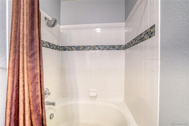 23070 York Ave, Parker, CO 80138 - bathroom featuring shower / tub combo and a textured wall