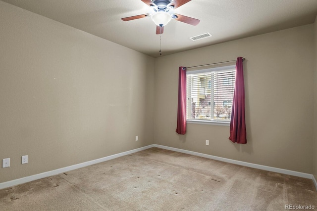 spare room featuring light colored carpet and ceiling fan