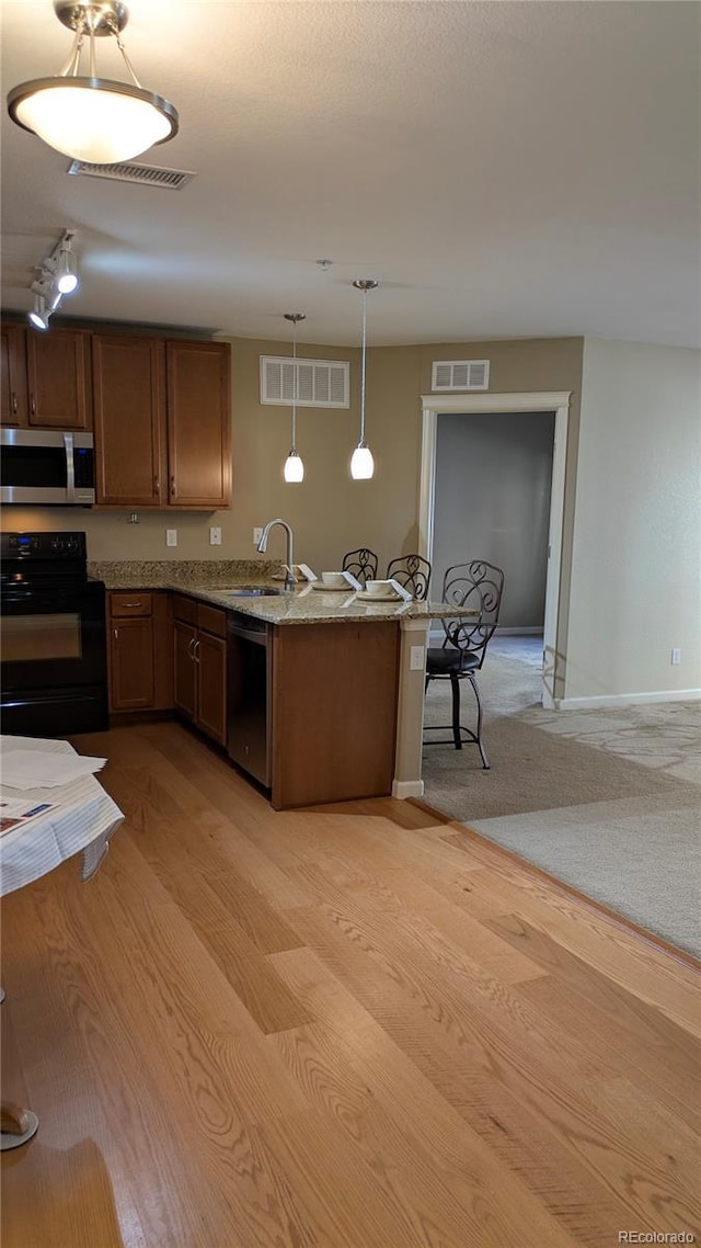 kitchen featuring a sink, visible vents, appliances with stainless steel finishes, and a peninsula