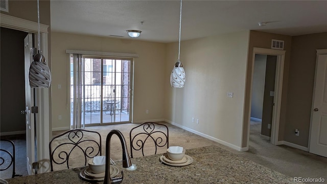 unfurnished dining area with visible vents, baseboards, and carpet floors