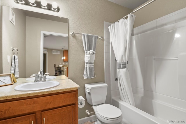 bathroom featuring visible vents, toilet, shower / tub combo with curtain, vanity, and a textured wall