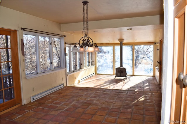 unfurnished sunroom with a baseboard radiator and a wood stove