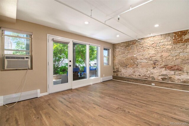 spare room featuring recessed lighting, wood finished floors, baseboards, and cooling unit