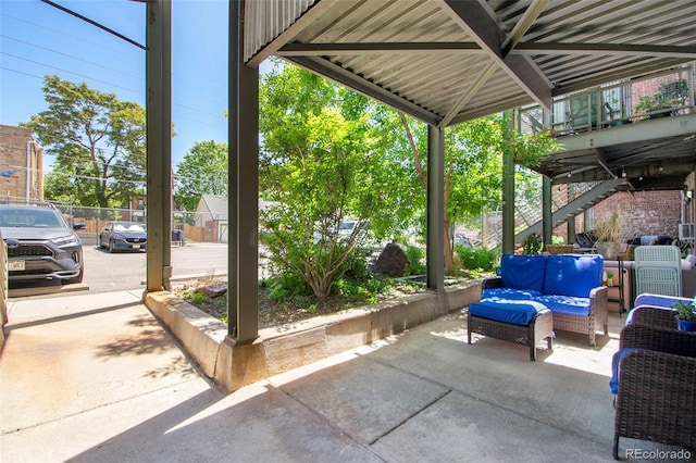 view of patio / terrace featuring outdoor lounge area, stairs, and fence