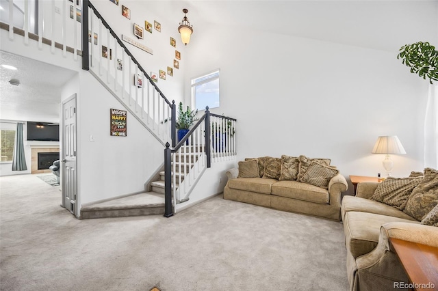 10530 Mount Columbia Pl, Parker, CO 80138 - living area featuring carpet, plenty of natural light, stairs, and a glass covered fireplace