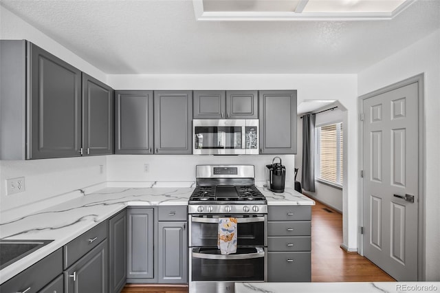 10530 Mount Columbia Pl, Parker, CO 80138 - kitchen with stainless steel appliances, gray cabinets, and wood finished floors