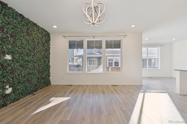 unfurnished living room featuring light hardwood / wood-style floors and a chandelier