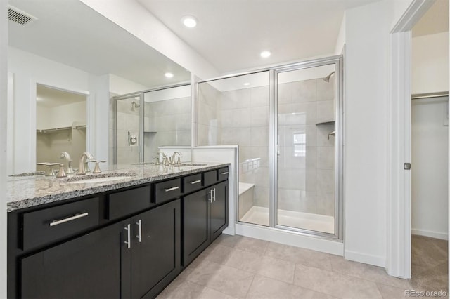 bathroom with tile patterned flooring, an enclosed shower, and vanity