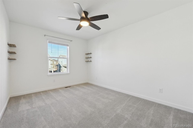 spare room with ceiling fan and light carpet