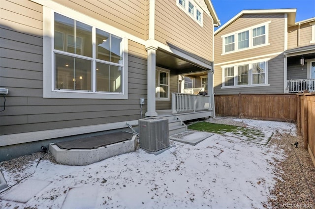 snow covered property entrance featuring central AC