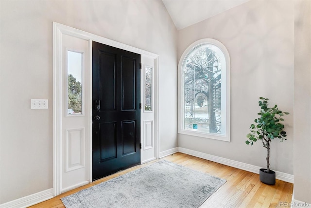 entrance foyer featuring light wood-type flooring, lofted ceiling, and plenty of natural light