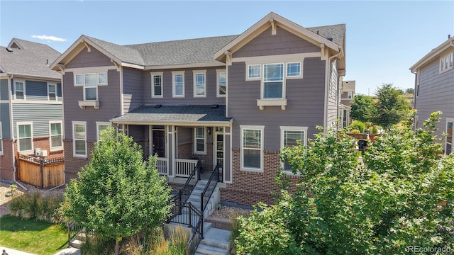 14074 Jackson St, Thornton, CO 80602 - view of front of home with covered porch, brick siding, and roof with shingles