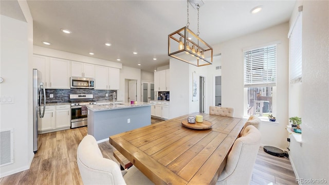 14074 Jackson St, Thornton, CO 80602 - dining area with light wood finished floors, recessed lighting, and a chandelier