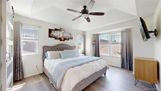 14074 Jackson St, Thornton, CO 80602 - bedroom featuring multiple windows, a raised ceiling, and light wood-style floors