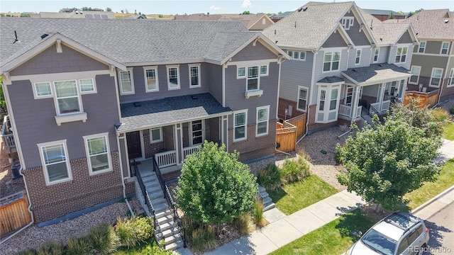 14074 Jackson St, Thornton, CO 80602 - view of front of property with stairway, a porch, a residential view, brick siding, and a shingled roof