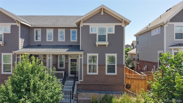 14074 Jackson St, Thornton, CO 80602 - view of front of house featuring brick siding, covered porch, and roof with shingles