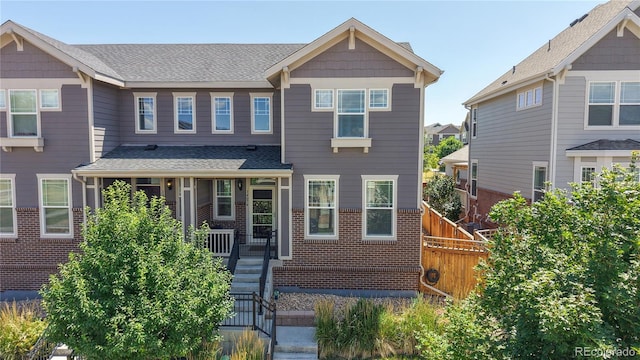 14074 Jackson St, Thornton, CO 80602 - view of front of property with a porch, brick siding, and a shingled roof