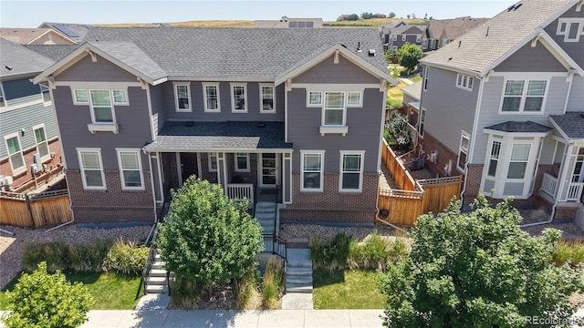 14074 Jackson St, Thornton, CO 80602 - view of front facade featuring stairway, brick siding, a residential view, and roof with shingles