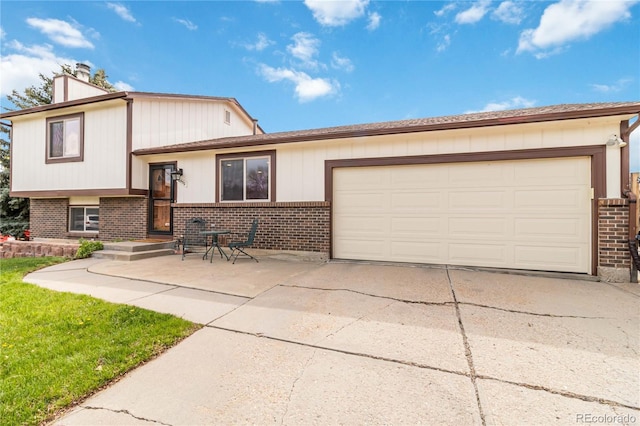10550 Routt St, Westminster, CO 80021 - tri-level home with an attached garage, a chimney, driveway, and brick siding