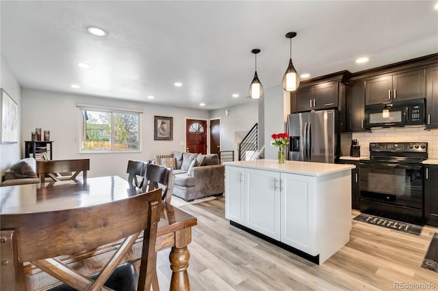 10550 Routt St, Westminster, CO 80021 - kitchen with backsplash, a center island, light countertops, black appliances, and open floor plan