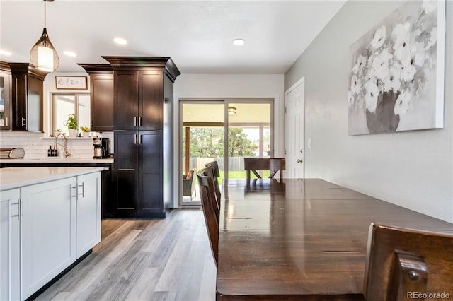 10550 Routt St, Westminster, CO 80021 - kitchen featuring dark brown cabinets, recessed lighting, tasteful backsplash, light wood-style flooring, and decorative light fixtures