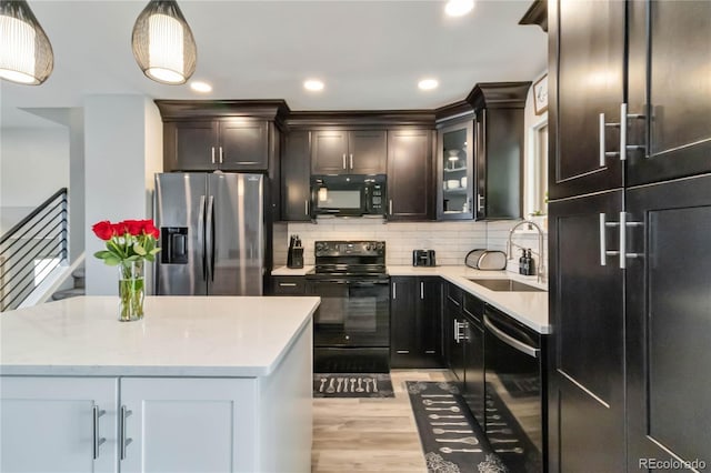 10550 Routt St, Westminster, CO 80021 - kitchen with a sink, light wood-style flooring, decorative light fixtures, decorative backsplash, and black appliances