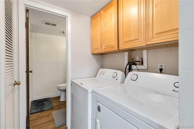 10550 Routt St, Westminster, CO 80021 - clothes washing area featuring visible vents, tile walls, cabinet space, wood finished floors, and washer and dryer