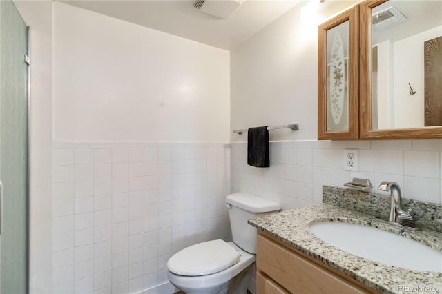 10550 Routt St, Westminster, CO 80021 - bathroom with vanity, visible vents, toilet, and tile walls
