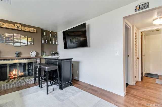 10550 Routt St, Westminster, CO 80021 - bar featuring baseboards, a brick fireplace, wood finished floors, and visible vents